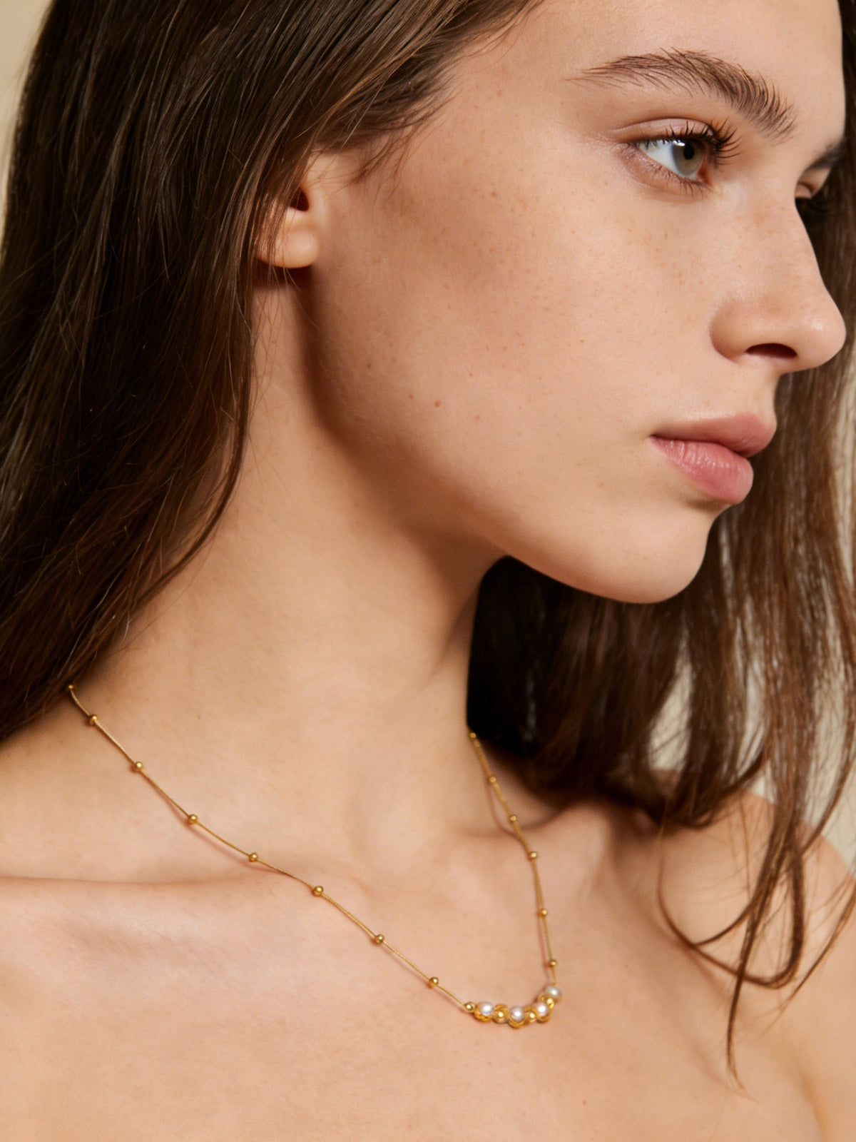 Accent Beaded Choker Necklace in gold with faux pearls, shown on a model, right profile view