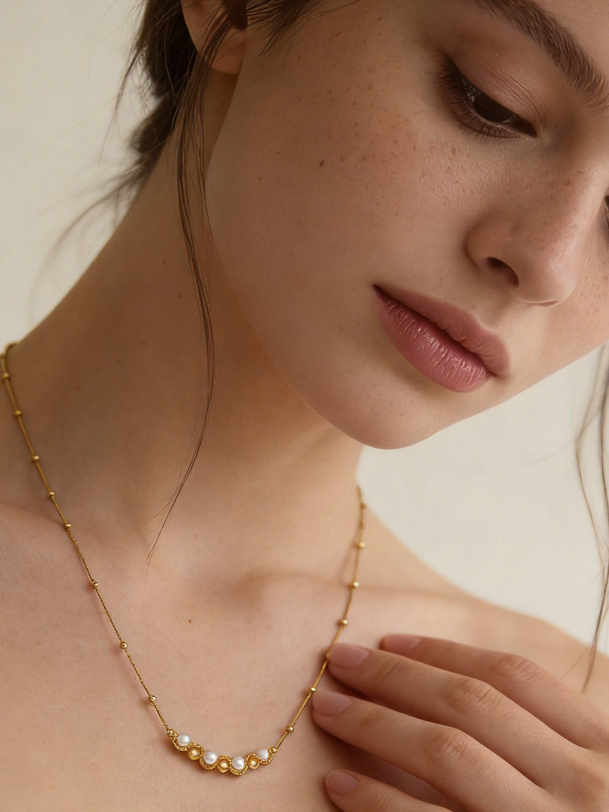 Accent Beaded Choker Necklace in gold with faux pearls, shown on a model, tilted close-up view
