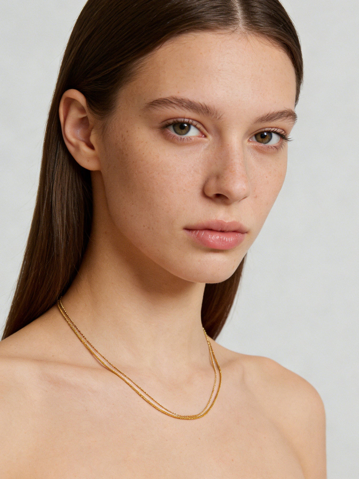 Double-Layered Choker Necklace in gold, shown on a model, front portrait view