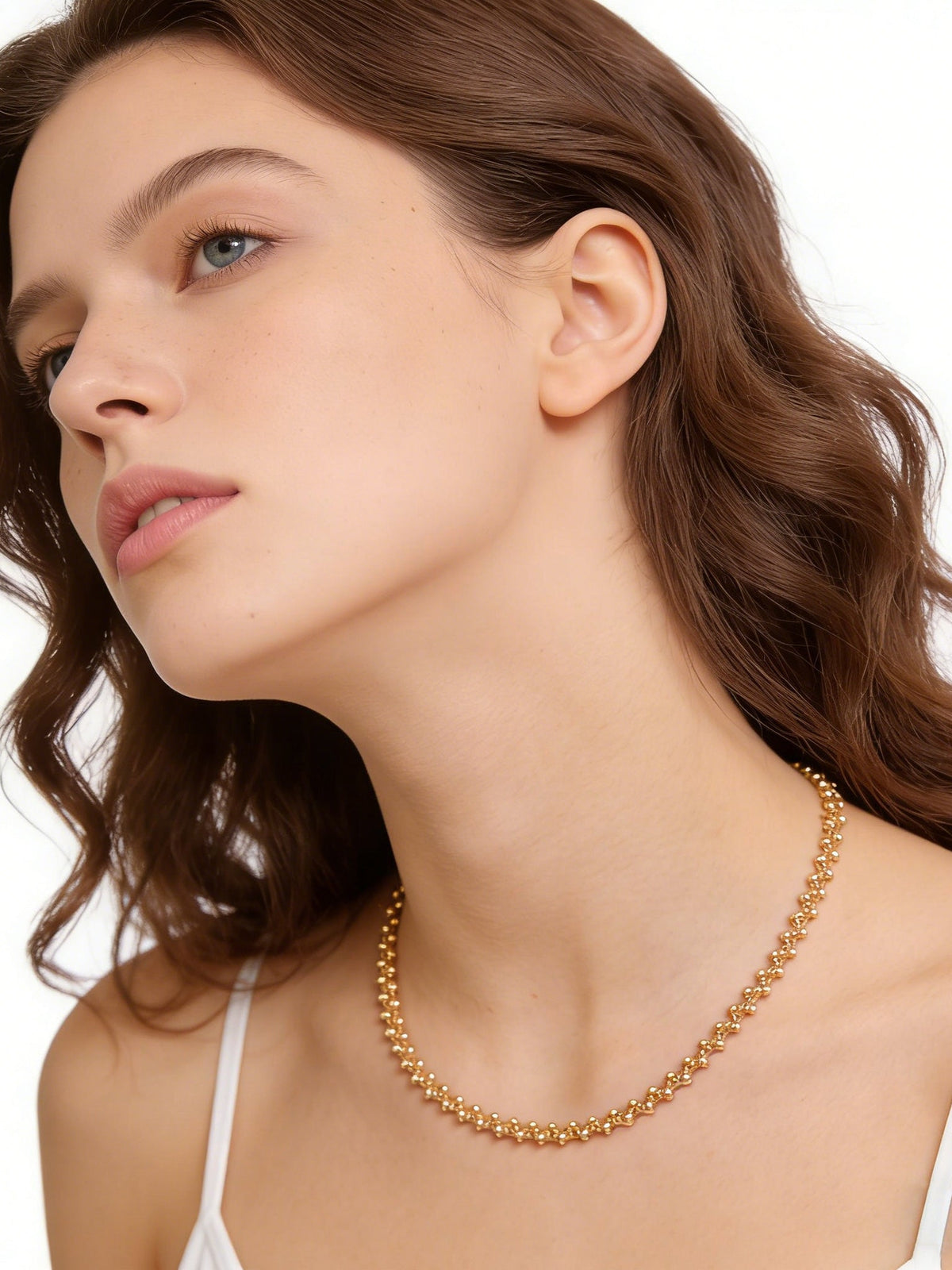 Golden Beaded Choker Necklace in gold, shown on a model looking up, three-quarter view