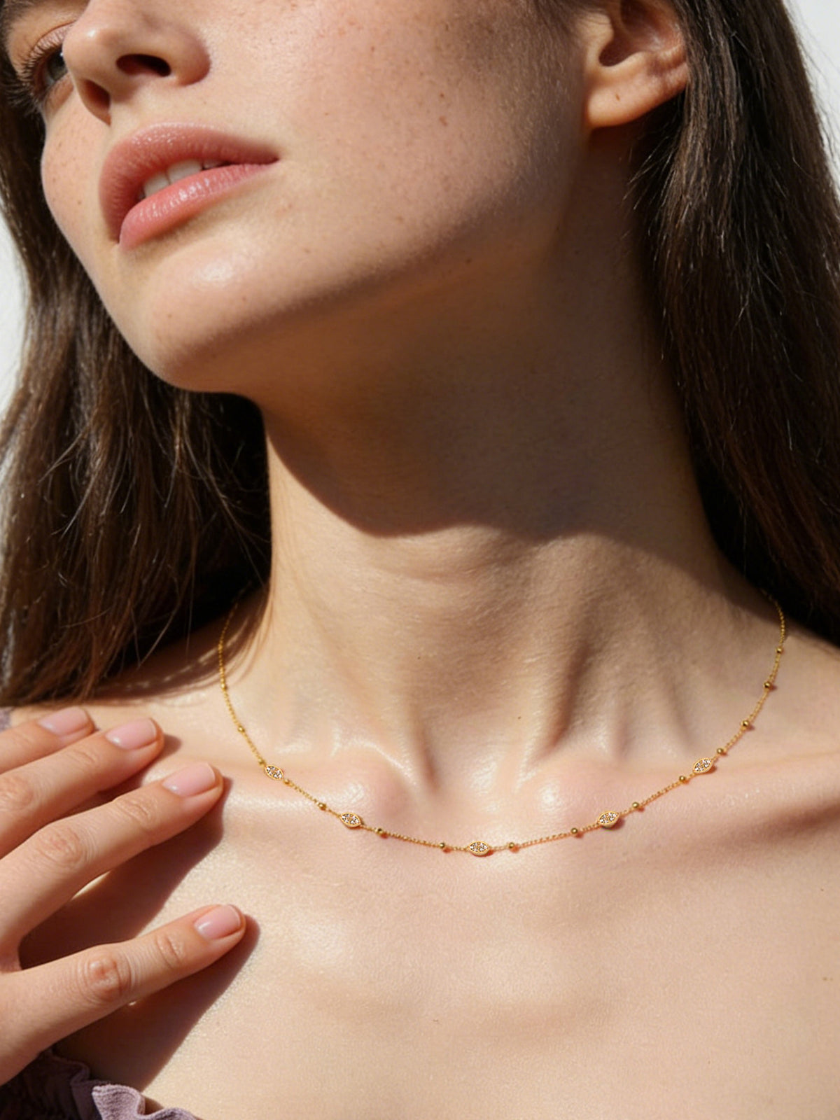 Sparkle Droplet Choker Necklace in gold with clear stones, shown on a model looking up to the left
