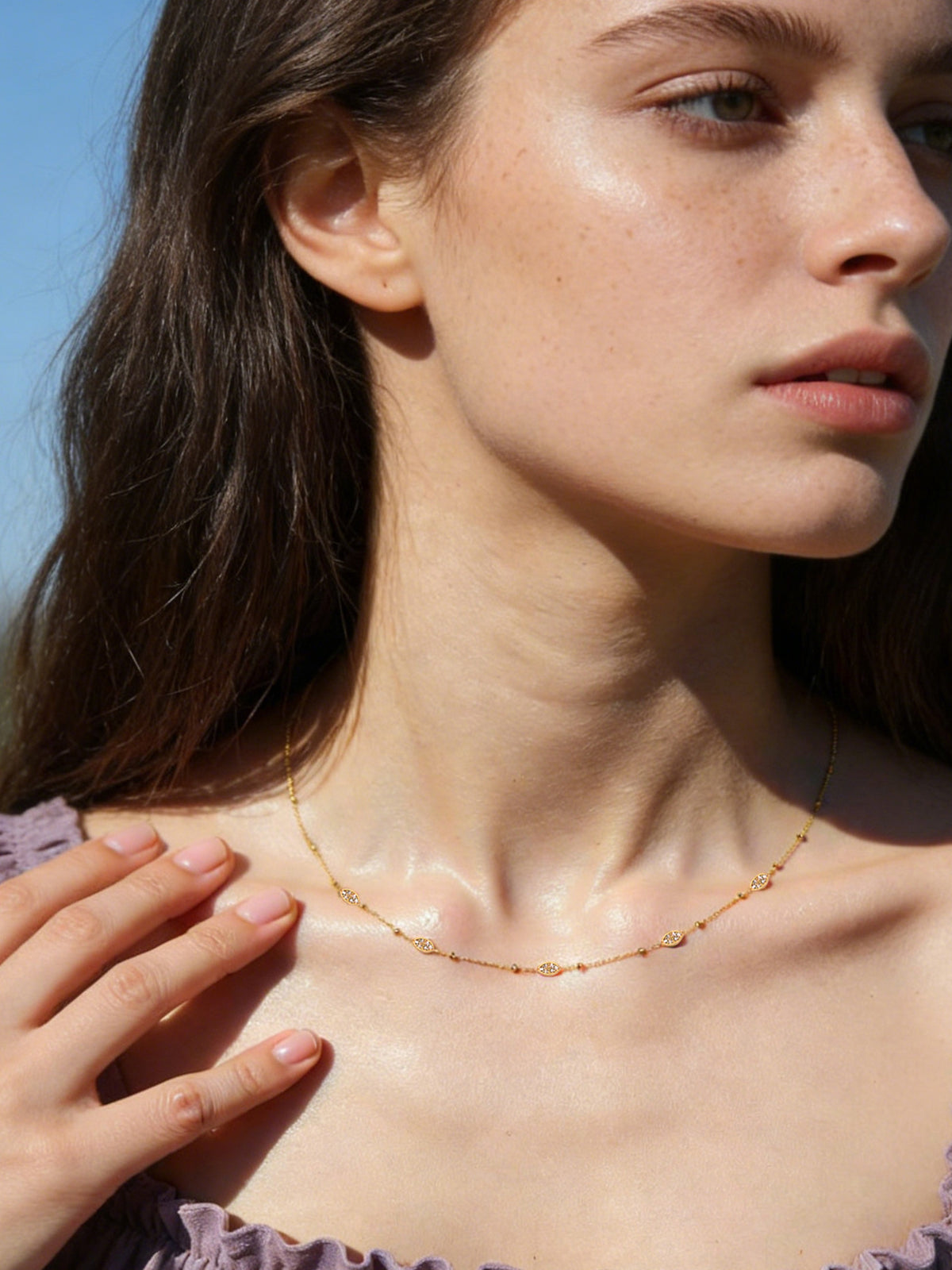 Sparkle Droplet Choker Necklace in gold with clear stones, shown on a model facing right, wide view