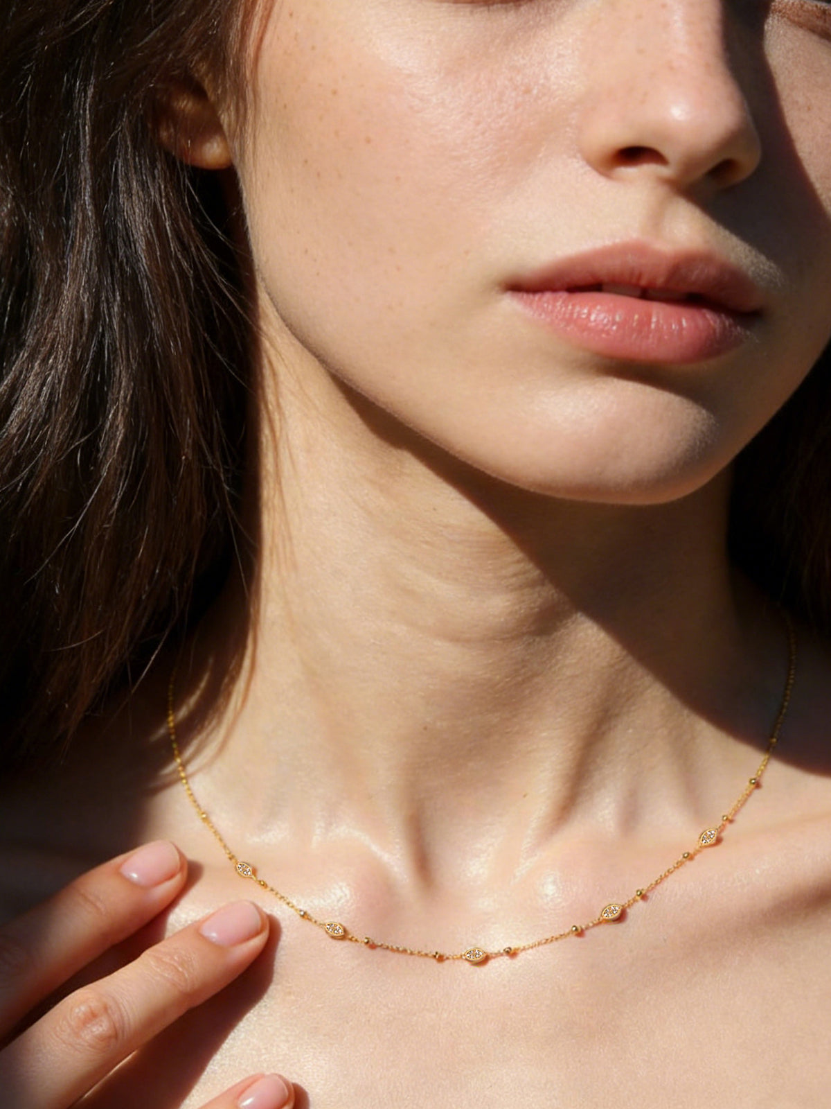 Sparkle Droplet Choker Necklace in gold with clear stones, shown on a model, three-quarter right view