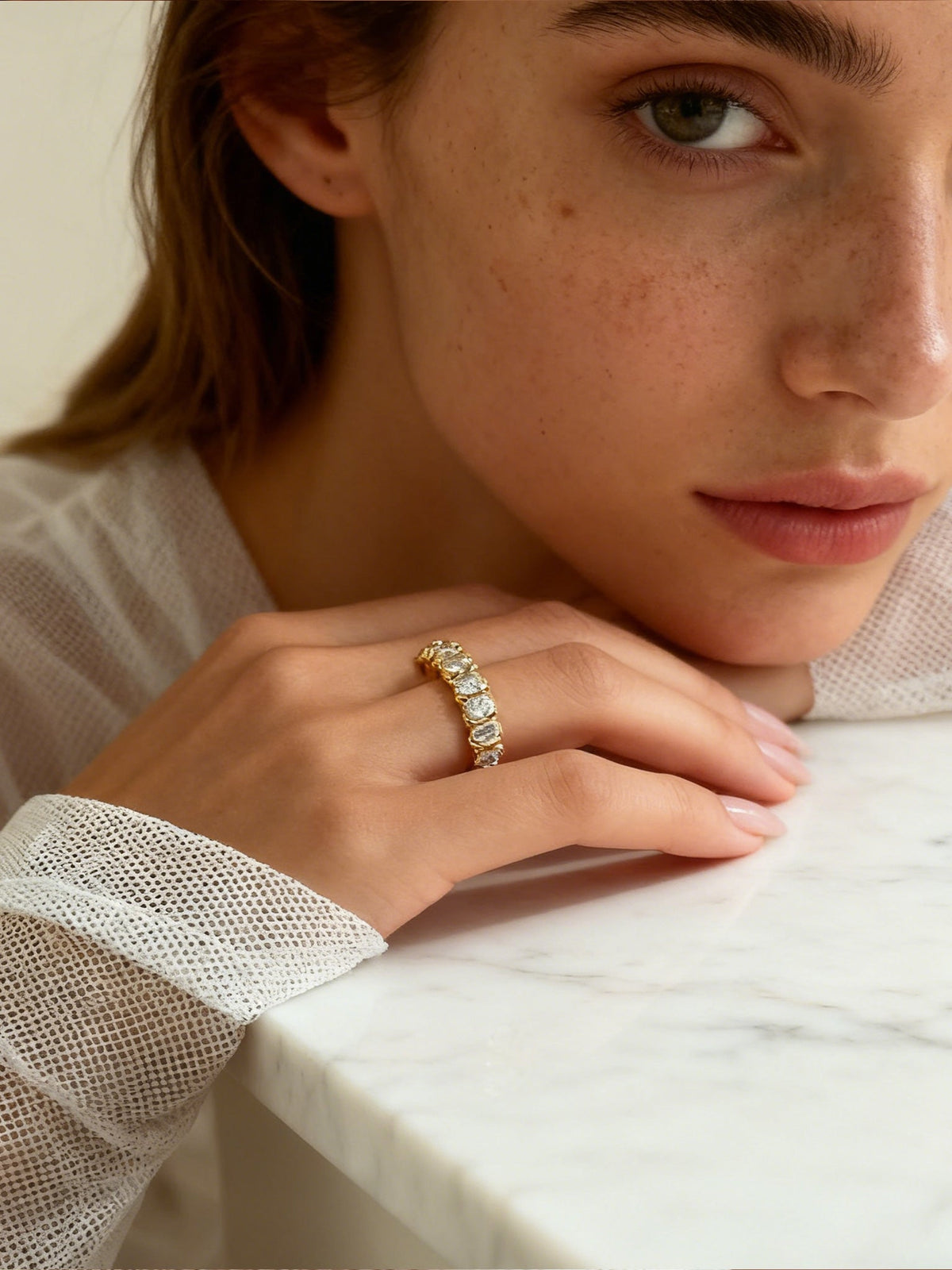 The Luminous Embrace Oval Eternity Ring in gold with clear stones, shown on a model, close up